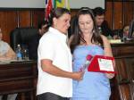 GLAUCIA,representando a Dr.a LUCILIA, entregando o mimo a outra homenageada a professora Carla Ortega